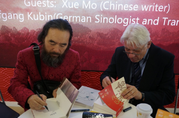 Xue Mo und Wolfgang Kubin signieren die Bücher